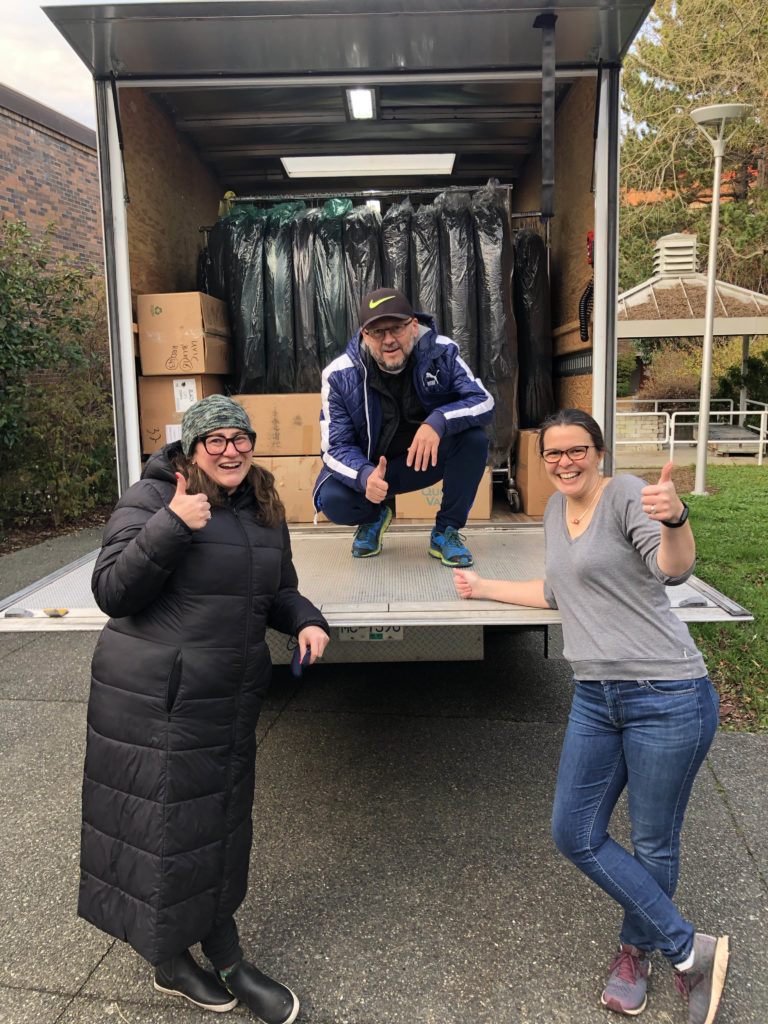 From left to right, Liz King and Rodolfo Calero from UBC and Jeanie Gunn from UVic load 600 caps and gowns at the UVic campus onto a truck bound for UBC on Sunday.