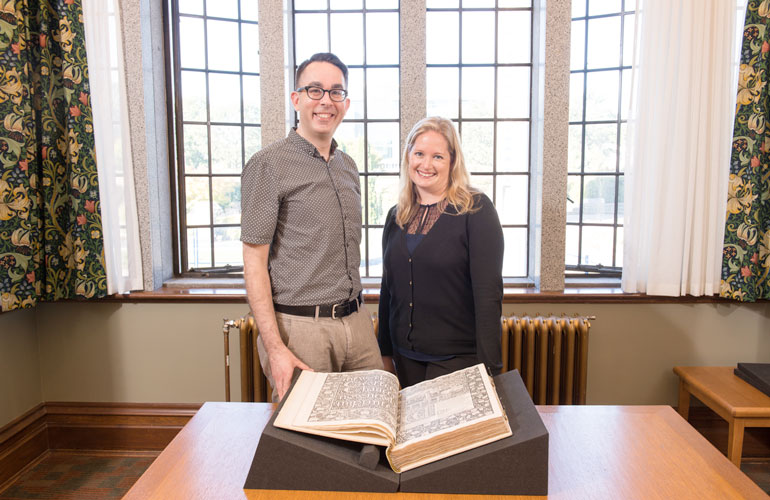Gregory Mackie, assistant professor in the department of English, and Katherine Kalsbeek, head of Rare Books and Special Collections, admire the Kelmscott Chaucer. Credit: Paul Joseph 