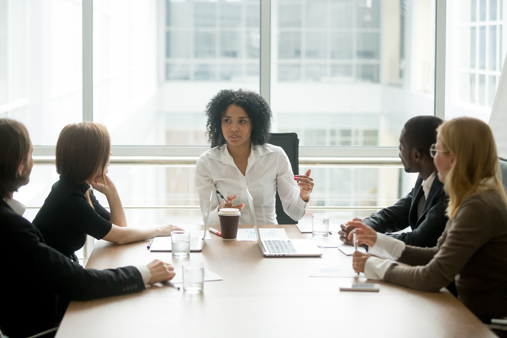 Black female boss leading corporate meeting talking to diverse