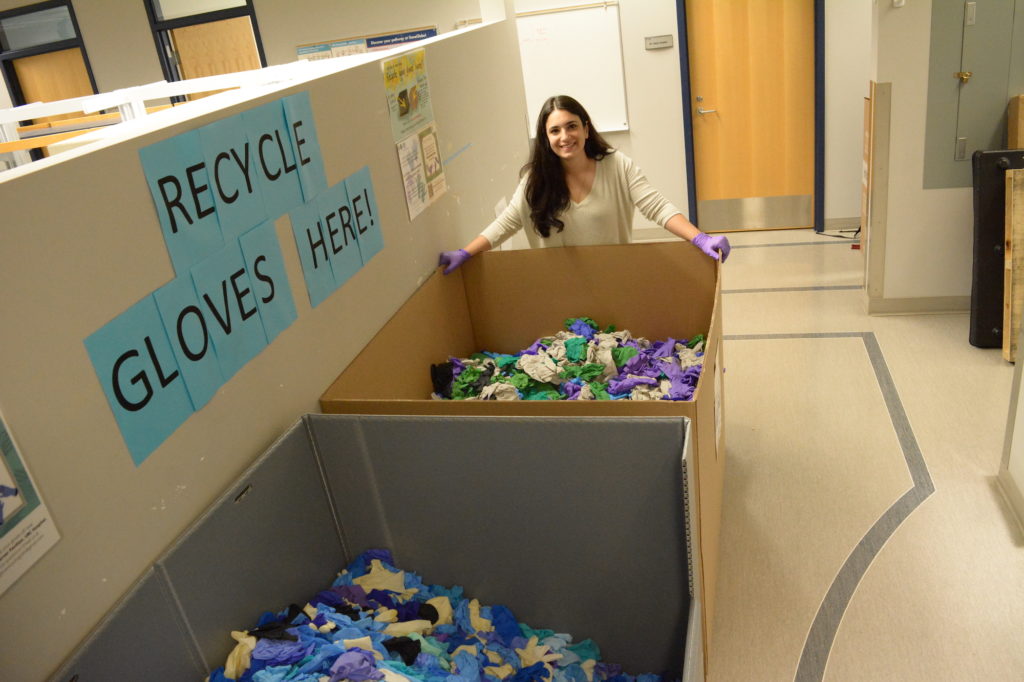 Melody Salehzadeh, a doctoral student in the department of zoology, with boxes of rubber gloves.