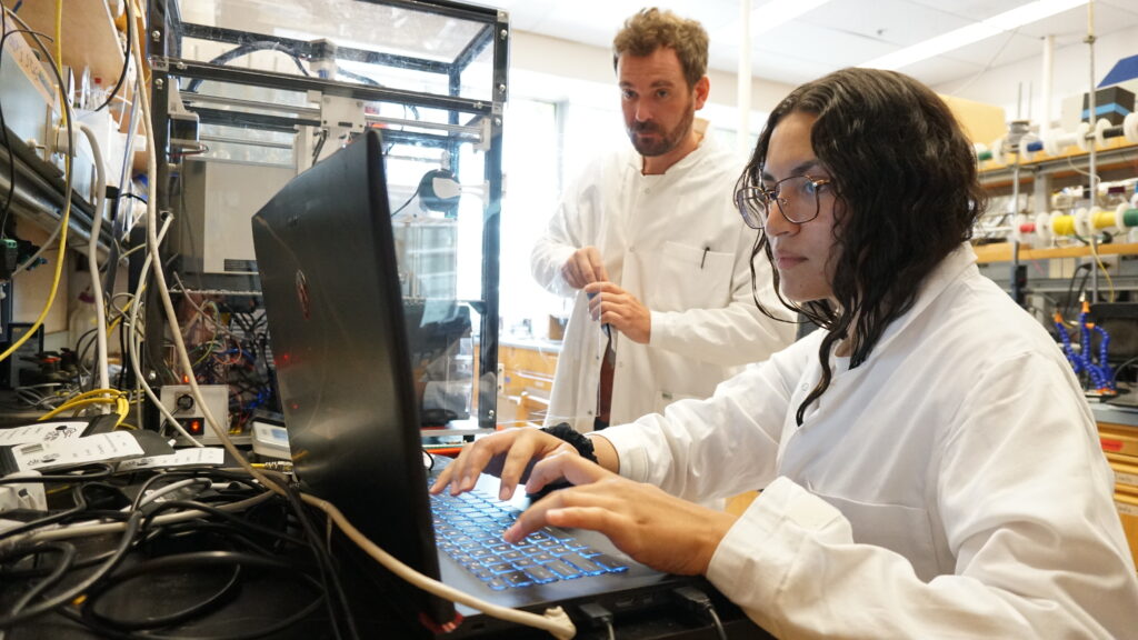 9. UBC doctoral student Sara Guzman and engineering technician Dr. Matthew Reish working with a portable drug tester prototype in the Hein lab.