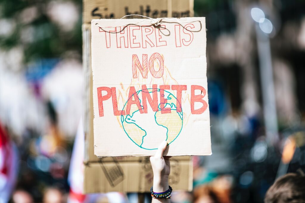 A picket sign with a graphic of the Earth overlaid with the text, 