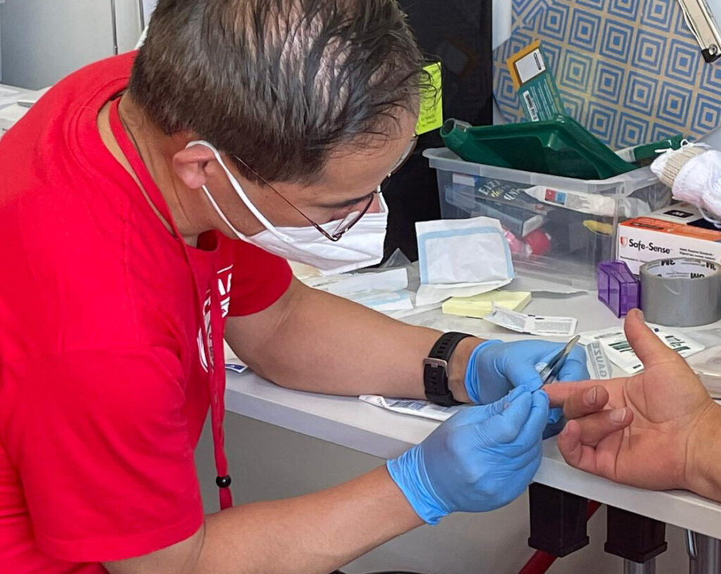 Dr. Hubert Chao, a primary care physician at UBC's student health clinic, treats a patient in May 2022 while on a CMAT mission to provide medical care in Ukraine.