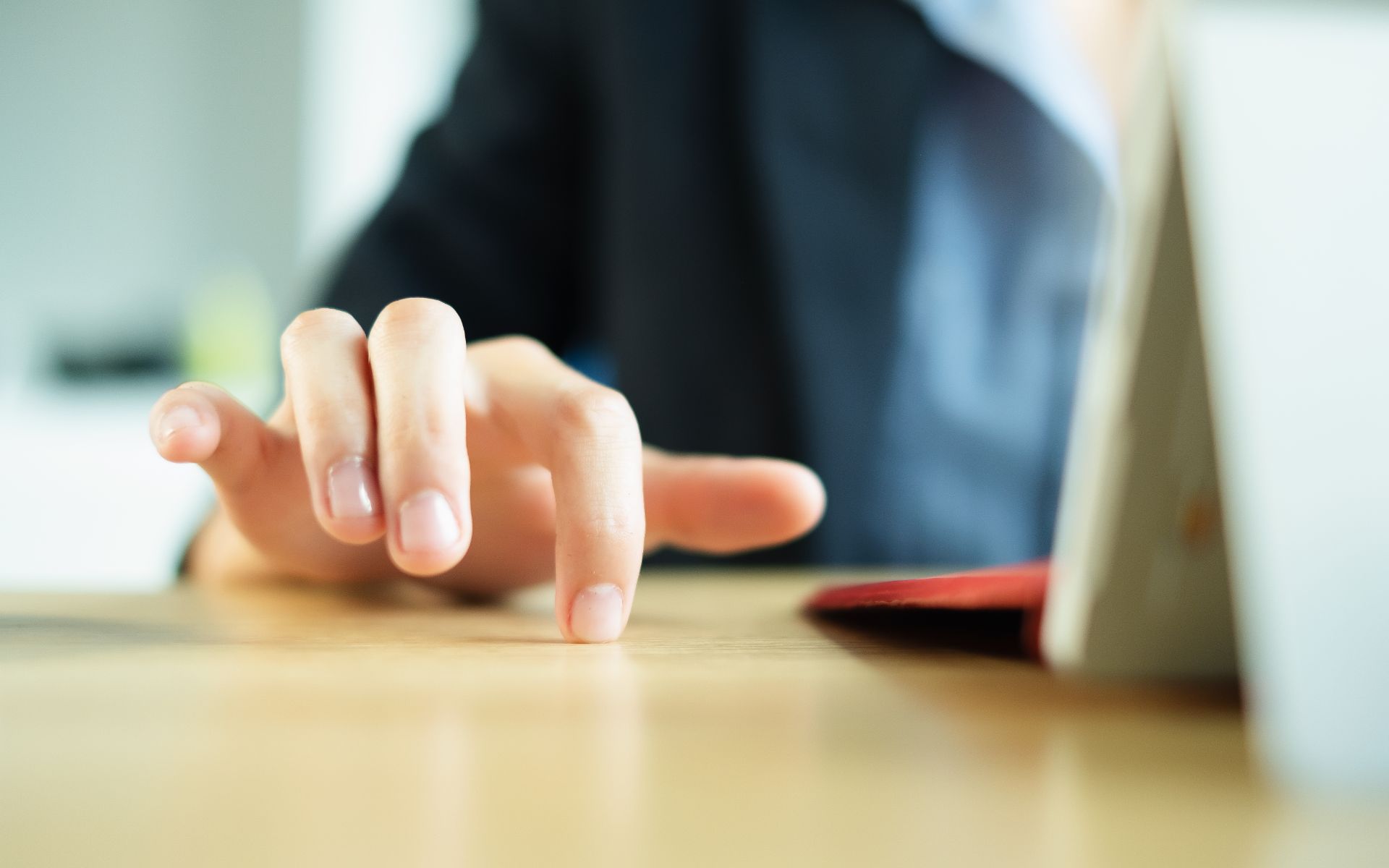 Close up image of someone's right hand fidgeting on a table.